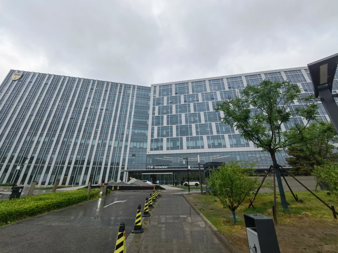 Full exterior view of Beijing GOBROAD Hospital modern glass building with outpatient entrance