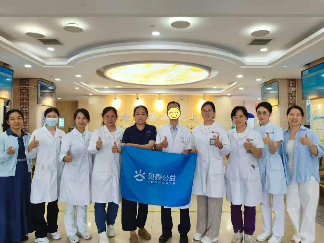 A Feng and the volunteer team at Beijing GOBROAD Boren Hospital, holding a Beike Public Welfare banner